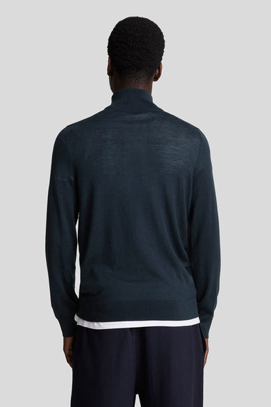 Pull à col rond bleu de LYLE & SCOTT, porté avec un t-shirt blanc et un pantalon marine, vue de dos.