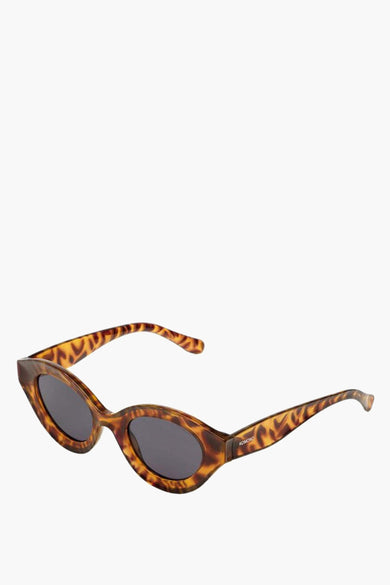 Lunettes de soleil turquoise de KOMONO avec motif écaille de tortue.