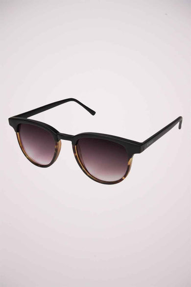 Lunettes de soleil noires by KOMONO, avec dégradé foncé et motif écaille de tortue sur la monture inférieure.