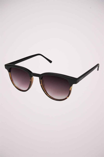 Lunettes de soleil noires by KOMONO, avec dégradé foncé et motif écaille de tortue sur la monture inférieure.