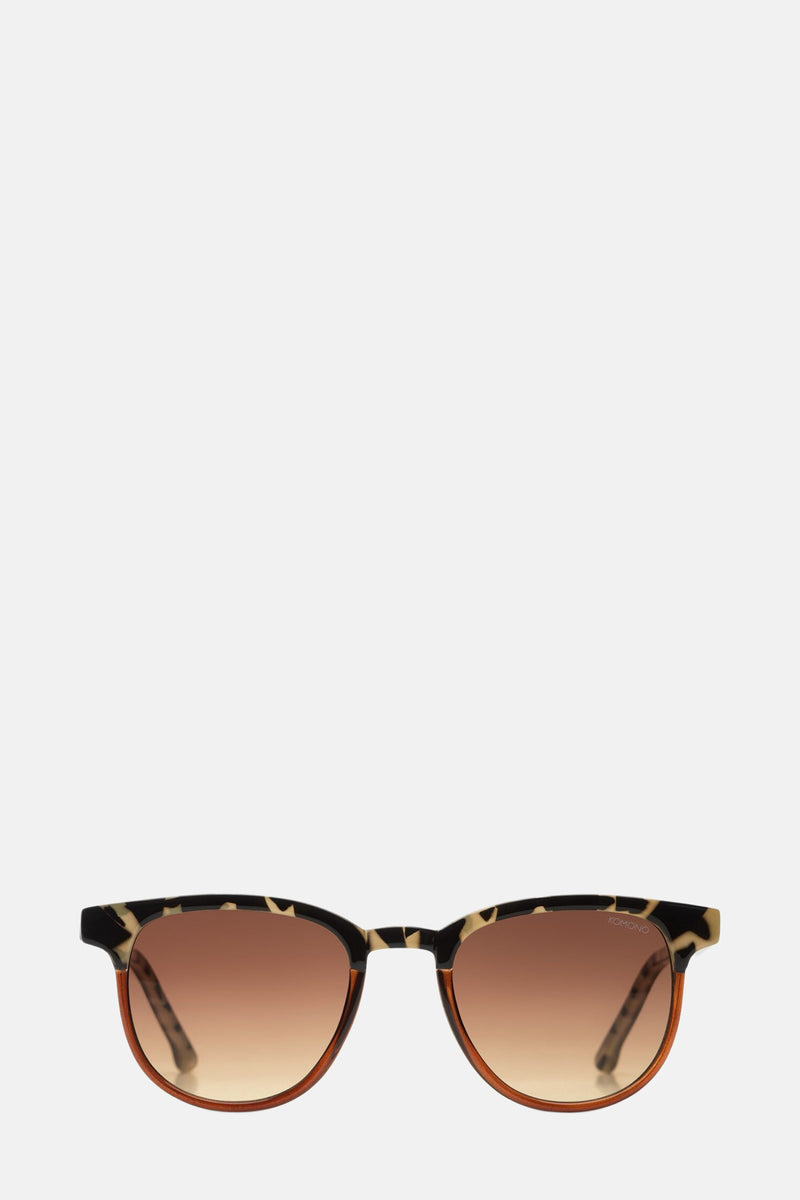 Lunettes de soleil brunes par Komono, avec monture à motif léopard et détails écaille de tortue.