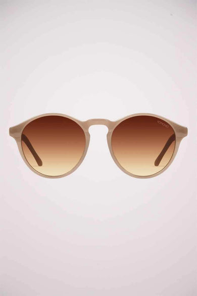 Lunettes de soleil beiges de KOMONO, avec des verres fumés marron dégradé.