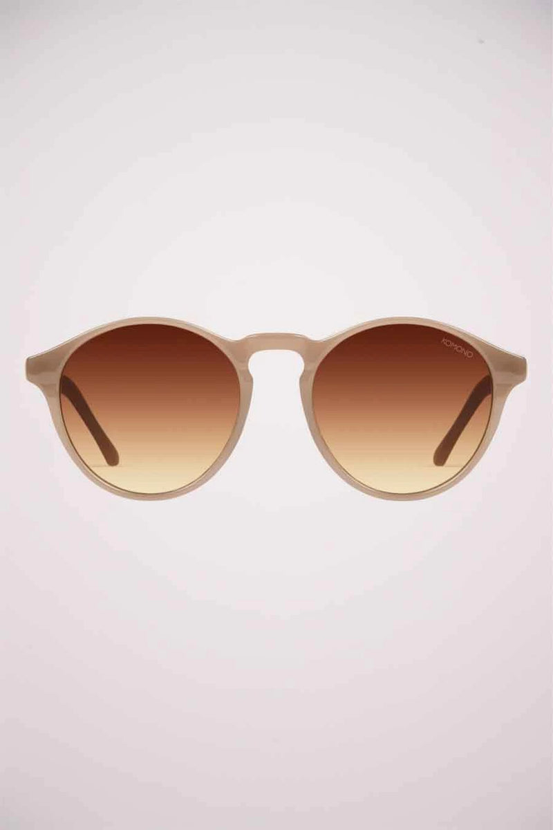 Lunettes de soleil beiges de KOMONO, avec des verres fumés marron dégradé.