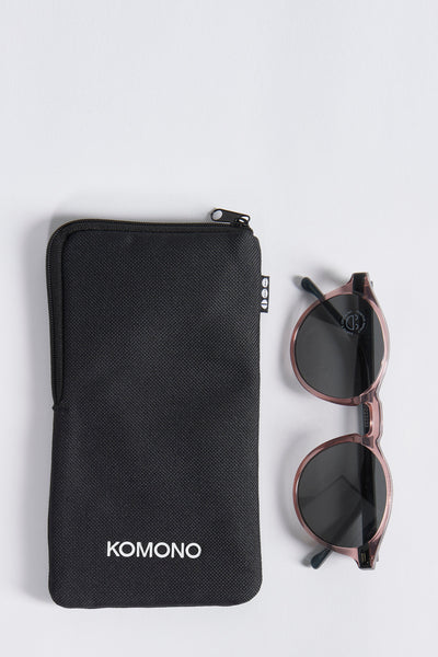 Multikleuren roze zonnebril van KOMONO, met een zwart etui met ritssluiting.