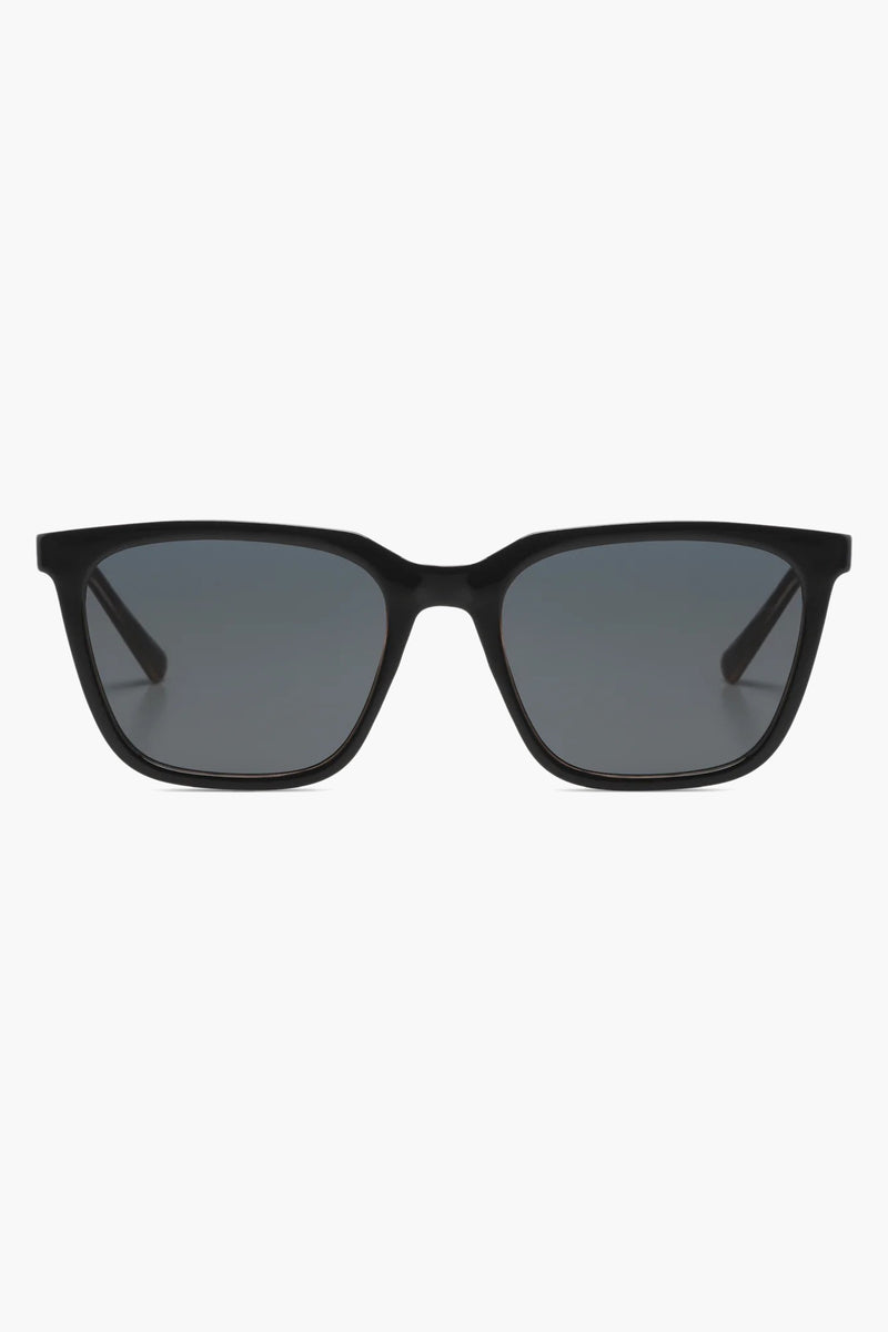 Lunettes de soleil noires de KOMONO, monture carrée classique et verres gris fumé.