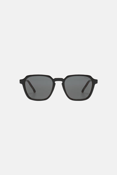 Lunettes de soleil noires de Komono, monture carrée et verres teintés unis.