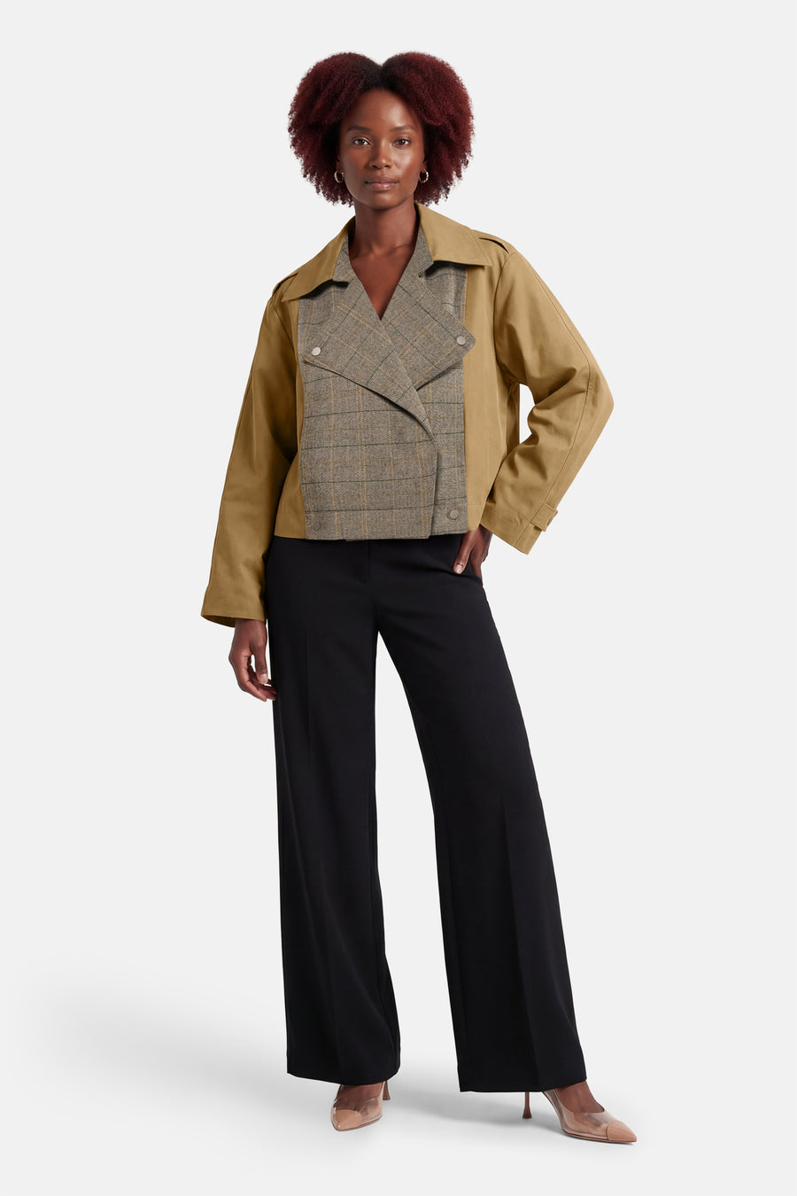 Veste courte beige d'ADORE, avec empiècement à carreaux sur le devant, portée avec un pantalon noir taille haute.
