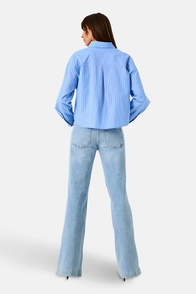Blauwe gestreepte blouse van GARCIA, met lange mouwen en plooien aan de achterkant, gedragen met een uitlopende spijkerbroek.