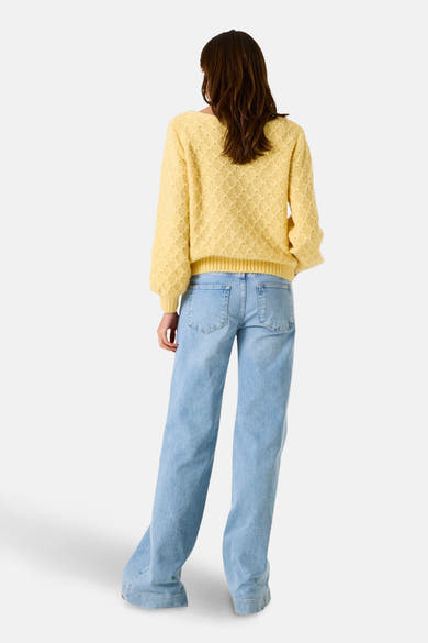 Pull jaune de GARCIA, avec un motif en losange et porté avec un jean décontracté.