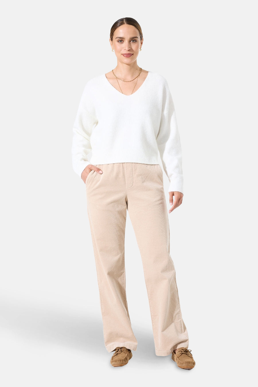Pull col V blanc de GARCIA, porté avec un pantalon beige en velours côtelé et des mocassins bruns.
