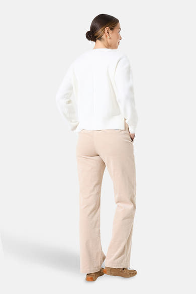 Pull col V blanc de GARCIA, porté avec un pantalon en velours côtelé beige et des mocassins.