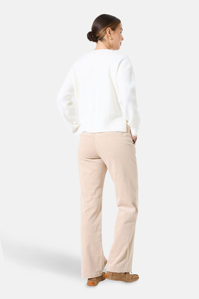 Pull col V blanc de GARCIA, porté avec un pantalon en velours côtelé beige et des mocassins.
