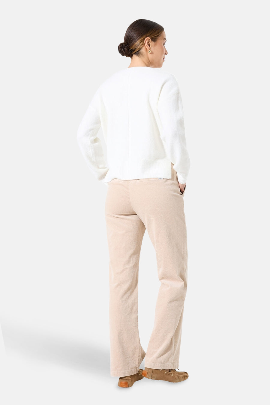 Pull col V blanc de GARCIA, porté avec un pantalon en velours côtelé beige et des mocassins.