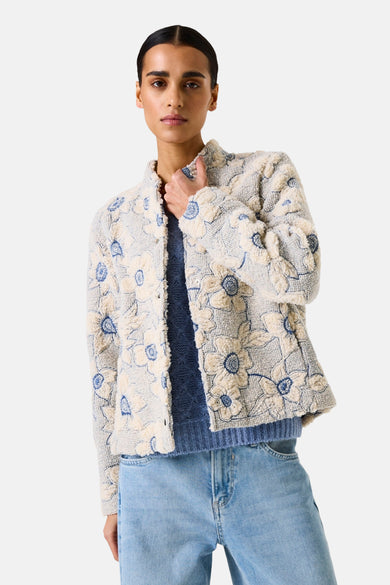 Veste courte en tissu à fleurs multicolores de GARCIA, portée sur un pull bleu et un jean décontracté.
