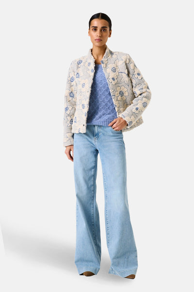 Veste courte fleurie de GARCIA, portée sur un pull bleu et un jean évasé.