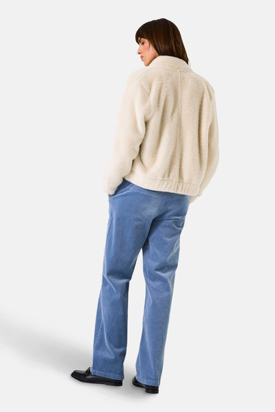 Ecru korte jas van GARCIA, met een bouclé textuur en gedragen met een blauwe fluwelen broek.