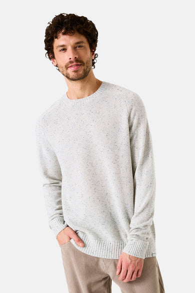 Pull col rond écru de GARCIA, en maille mouchetée, porté avec un pantalon en velours côtelé.
