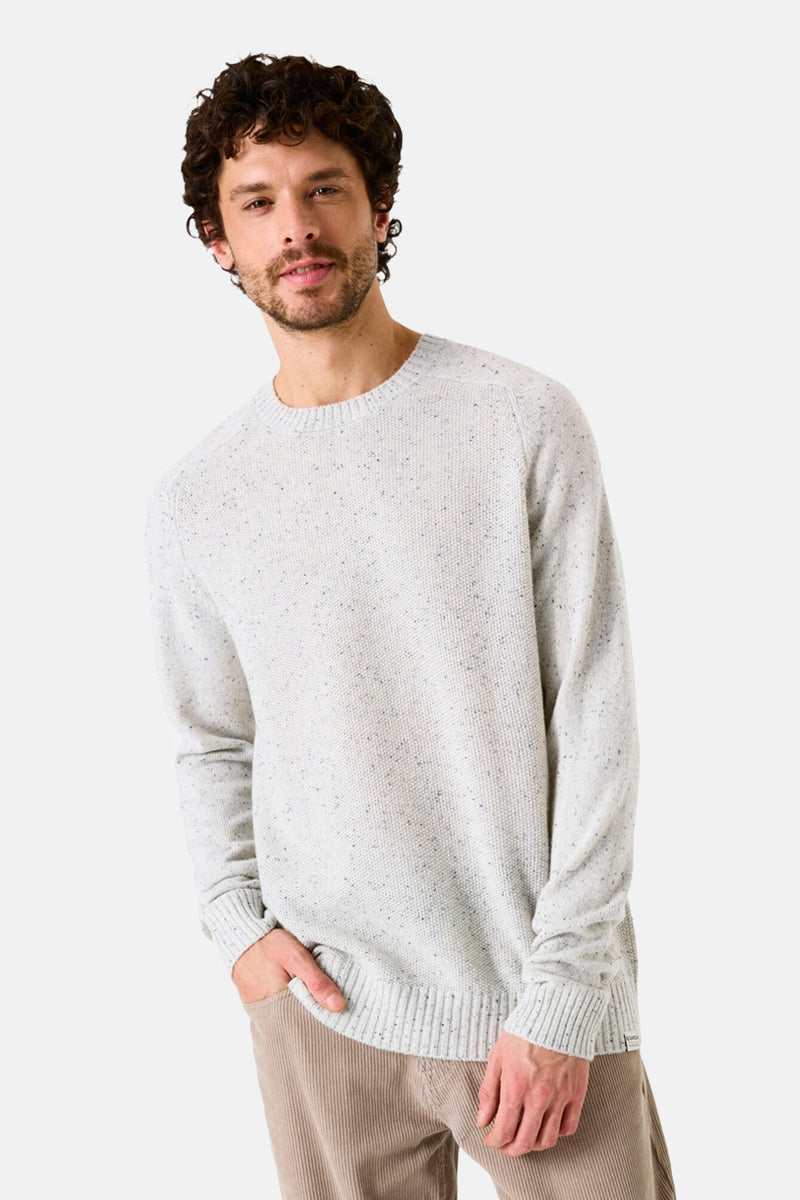 Pull col rond écru de GARCIA, en maille mouchetée, porté avec un pantalon en velours côtelé.