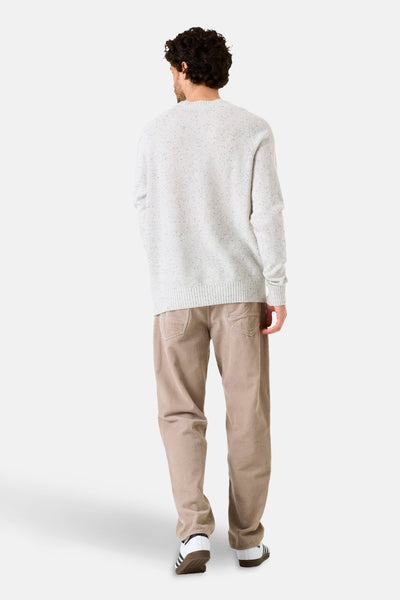 Pull col rond écru de GARCIA, en tricot texturé avec de fines mouchetures colorées, porté avec un pantalon en velours côtelé.
