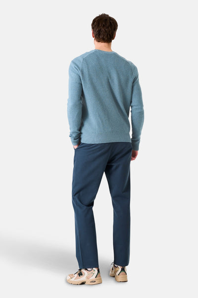 Pull col rond bleu de GARCIA, porté avec un pantalon bleu marine et des baskets beiges, vue de dos.