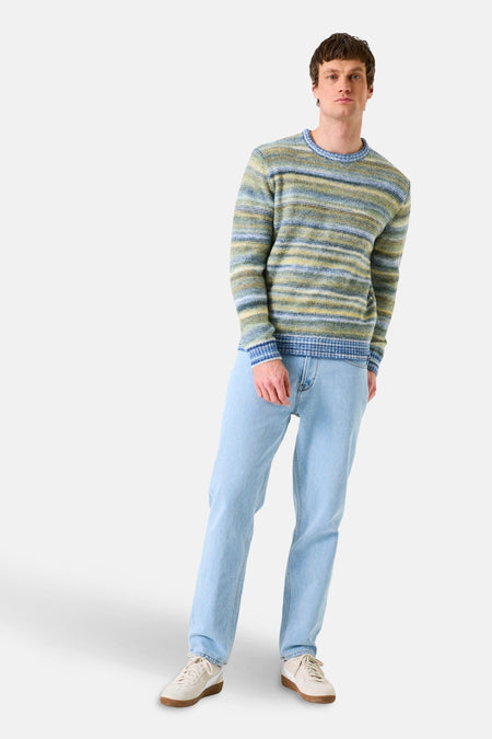 Pull col rond rayé en maille, de GARCIA, porté avec un jean bleu clair et des baskets beiges.
