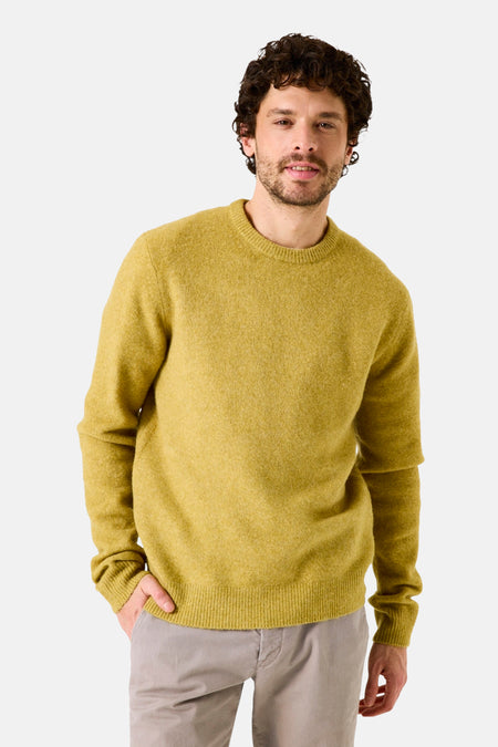 Pull col rond jaune par GARCIA, porté avec un pantalon clair uni, homme souriant regardant l'objectif.