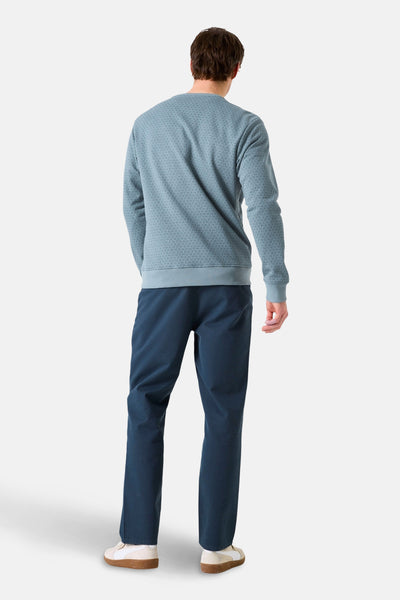 Blauwe rondehals sweatshirt van GARCIA, discreet toon-op-toon motief, gedragen met een broek en sneakers.