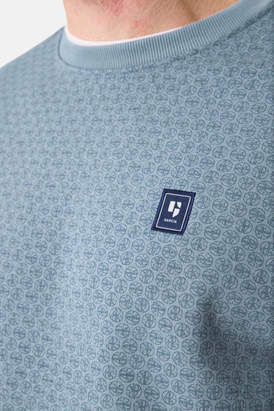 Sweat col rond bleu de GARCIA, motif imprimé subtil et patch logo sur la poitrine.
