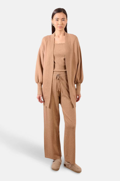 Beige gilet van Molly Bracken, open gedragen over een bijpassende set in glanzende stof.