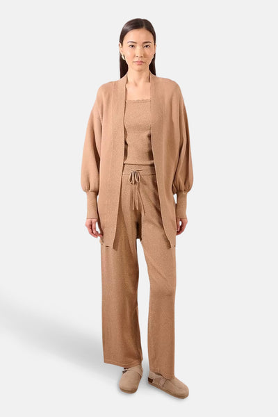 Beige gilet van Molly Bracken, open gedragen over een bijpassende set in glanzende stof.