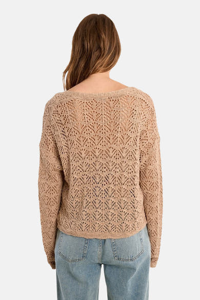 Gilet beige de Molly Bracken, en maille ajourée, porté avec un jean bleu, vue de dos.