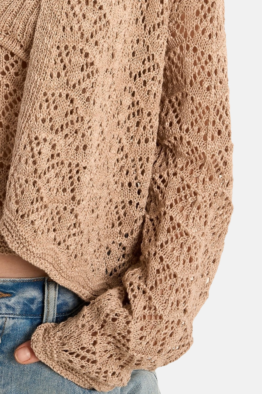 Gilet beige en maille ajourée de Molly Bracken, porté avec un jean bleu, coupe courte.
