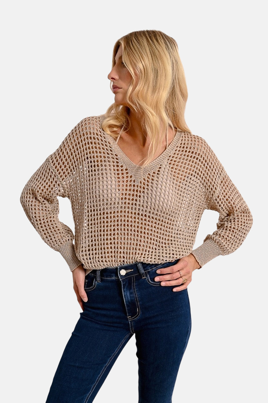 Beige V-hals trui van Molly Bracken, in opengebreide stof, gedragen met een donkerblauwe jeans.