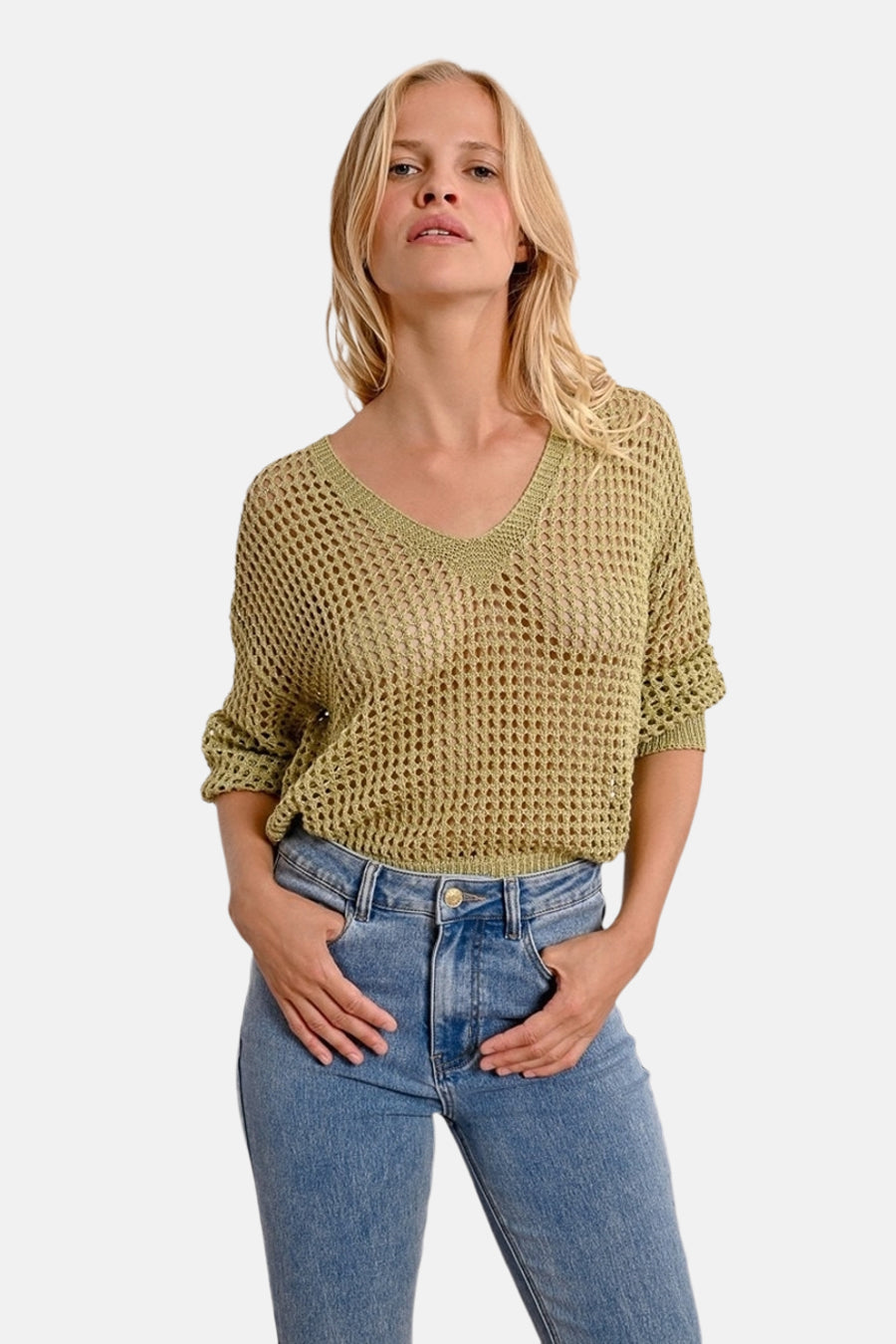 Molly Bracken groene V-hals trui in ajour gebreid, gedragen met een hoge taille blauwe jeans.