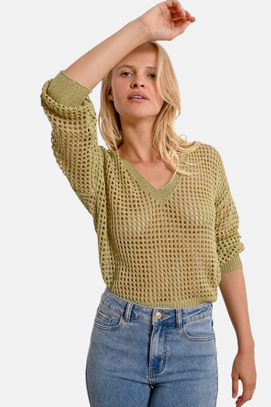 Pull à col en V vert de Molly Bracken, en maille ajourée porté avec un jean taille haute.
