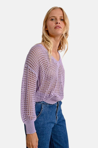 Molly Bracken paarse V-hals trui in ajour gebreid, gedragen met een high-waisted jeans.
