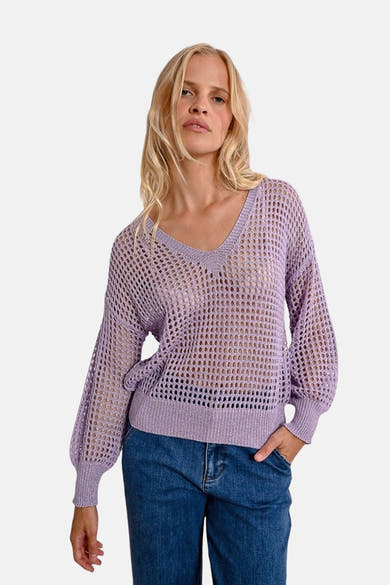 Paarse V-hals trui van Molly Bracken, in ajour gebreid, gedragen met een blauwe jeans.