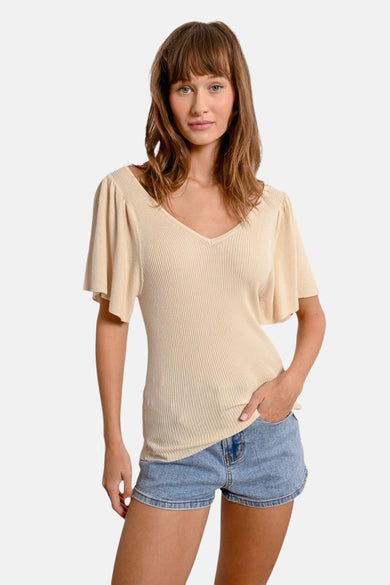 T-shirt écru à manches courtes de Molly Bracken, côtelé avec un col en V, porté avec un short en jean.
