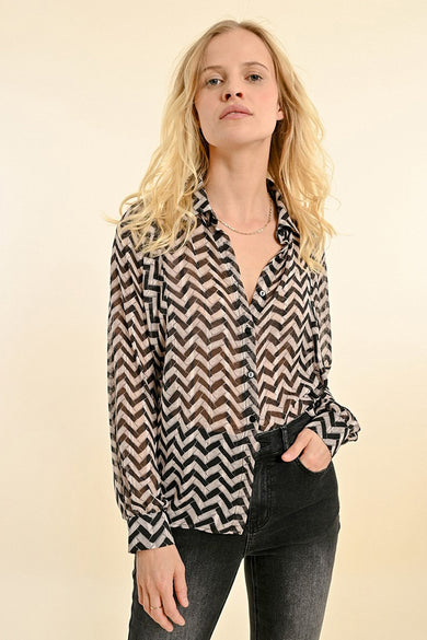 Chemise à manches longues noire, de Molly Bracken, avec un motif à chevrons transparent, portée avec un jean noir délavé.