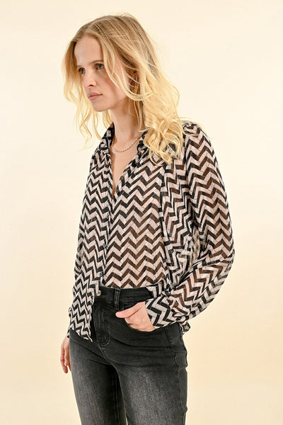 Chemise noire à manches longues de Molly Bracken, motif à chevrons, portée avec un jean noir.