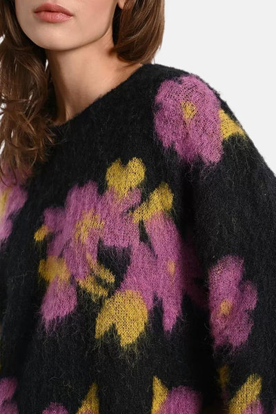 Pull à col rond multicolore de Molly Bracken, avec motif floral rose et jaune sur fond noir.

