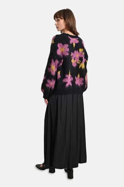 Pull à col rond multicolore de Molly Bracken avec motif floral sur une jupe noire longue.
