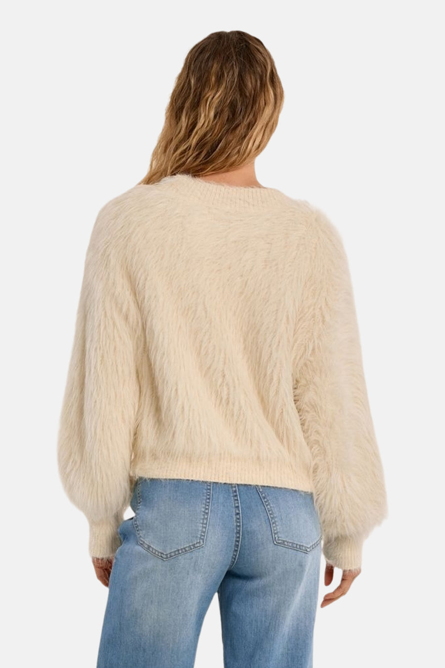Ecru fuzzy knit O-neck sweater back view with ribbed hem and cuffs, worn with light blue jeans