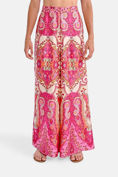 Korte meerkleurige jas van Molly Bracken, met roze en oranje paisley-patroon, gedragen met sandalen.