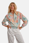 Korte meerkleurige jas van Molly Bracken met slangenprint en witte broek.