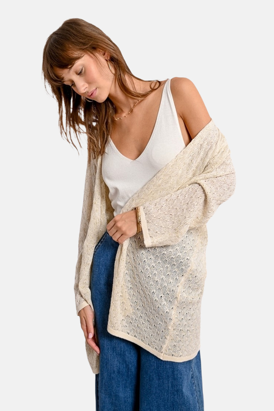 Ecru kanten vest van Molly Bracken, gedragen over een witte tanktop en een wijde blauwe jeans.