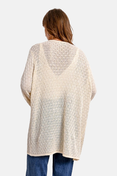 Ecru vest in openwork knit by Molly Bracken, worn over a light top and blue jeans.