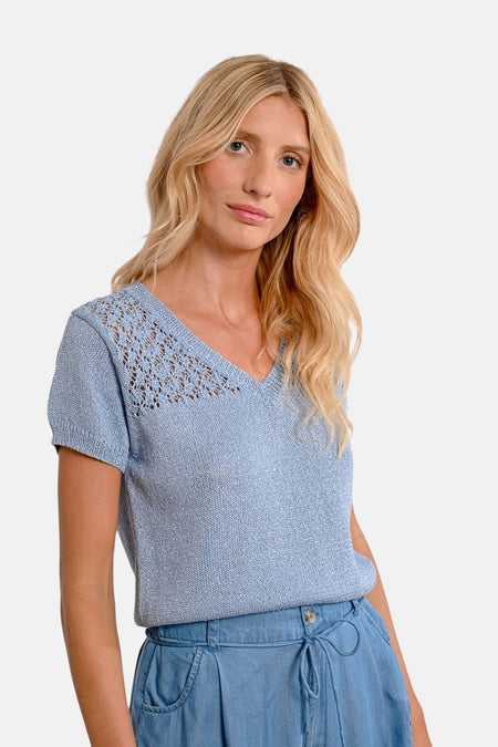 Blaauwe V-kraagpull-over van Molly Bracken met doorzichtige rand, gedragen met een hoge taille short.