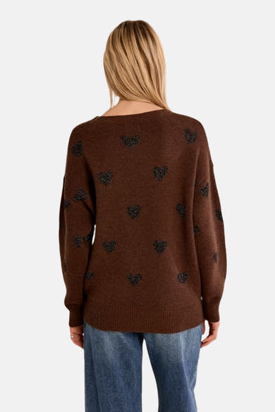 Brown O-neck sweater with black heart patterns, back view, worn with blue jeans