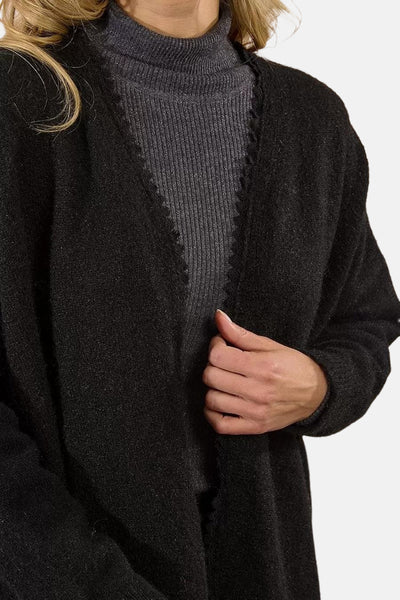 Zwarte Molly Bracken gilet met een geschulpte rand, gedragen over een grijze trui.